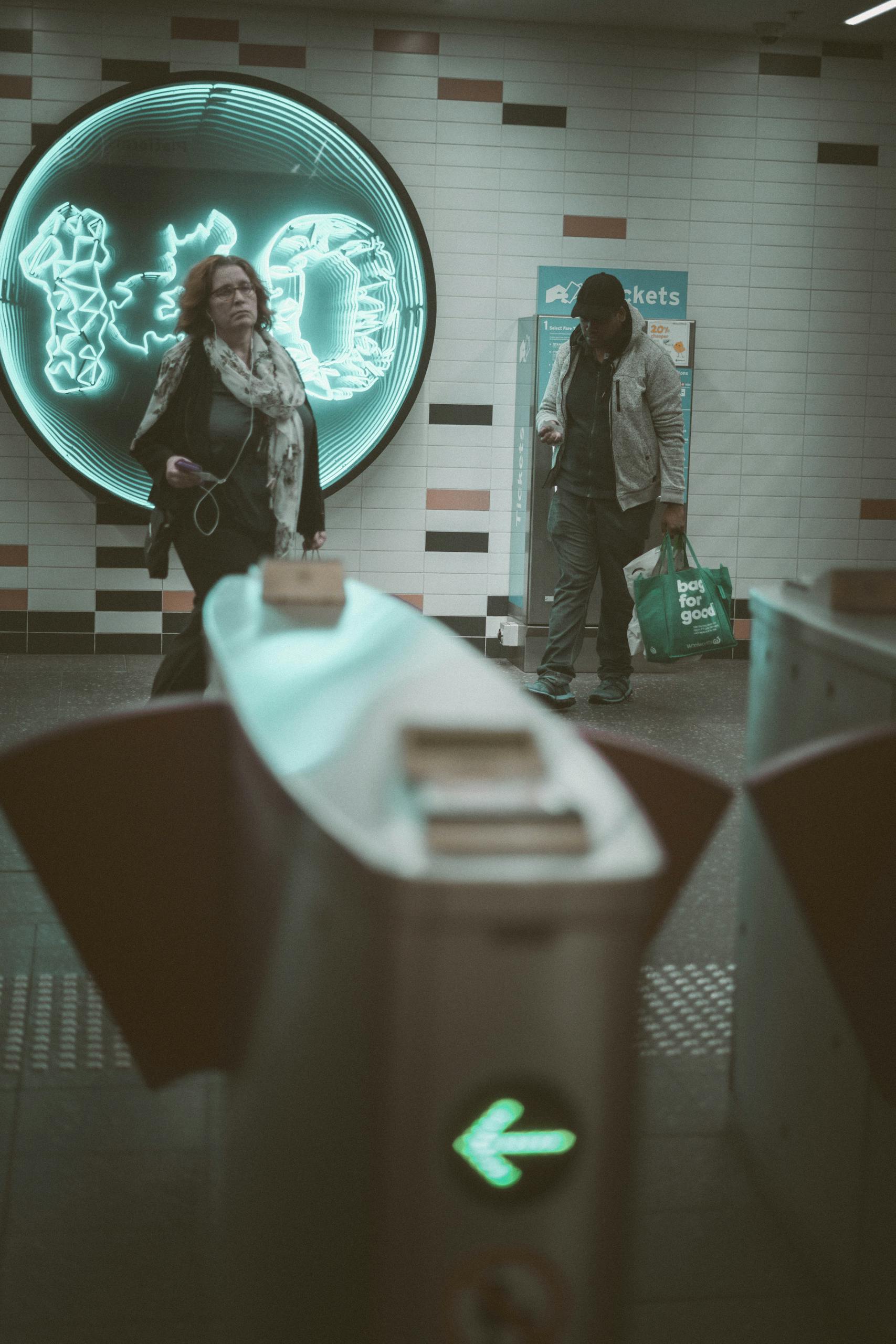 a candid capture of commuters in perth subway station with neon lit walls and ticket machine. 5010986 scaled