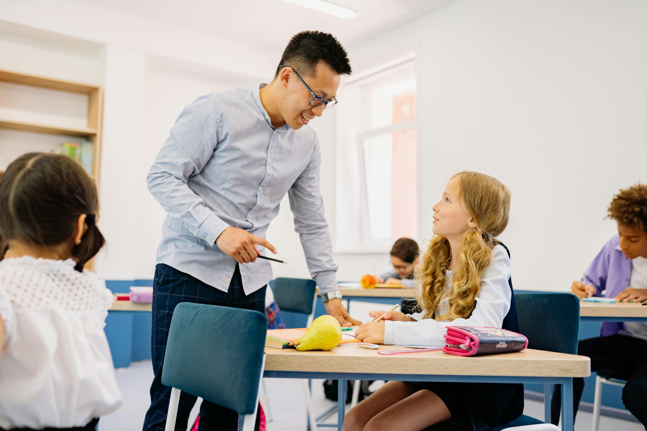 a male teacher interacting with diverse students in a bright classroom setting promoting active learning. 8617762 scaled