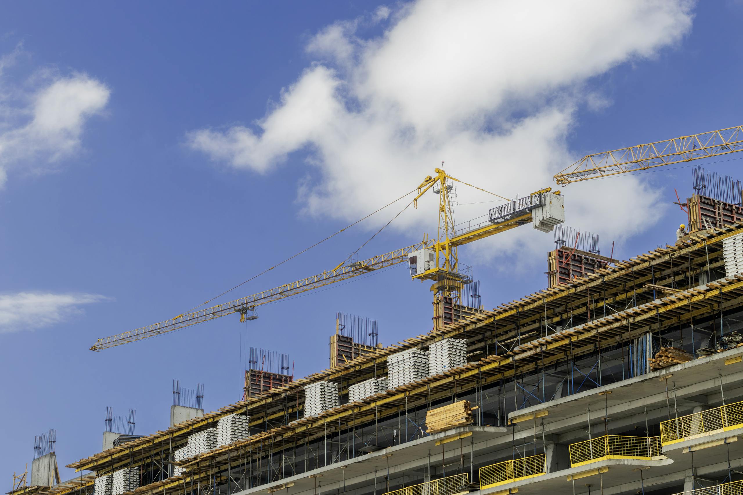 a modern construction site with cranes against a clear blue sky showcasing urban development. 36065437 scaled