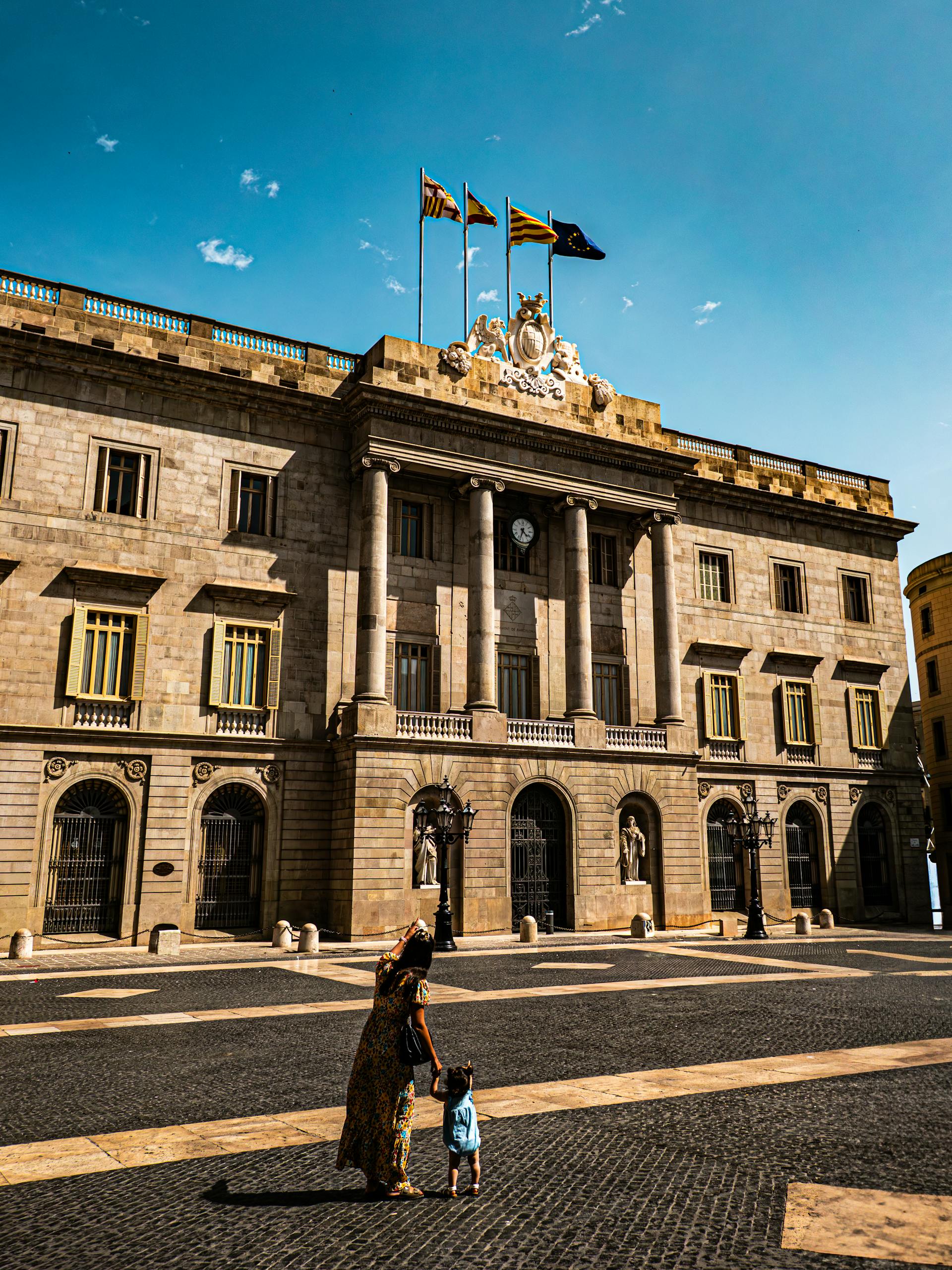 a woman and child outside the historic city hall in barcelona spain. 32784595 scaled