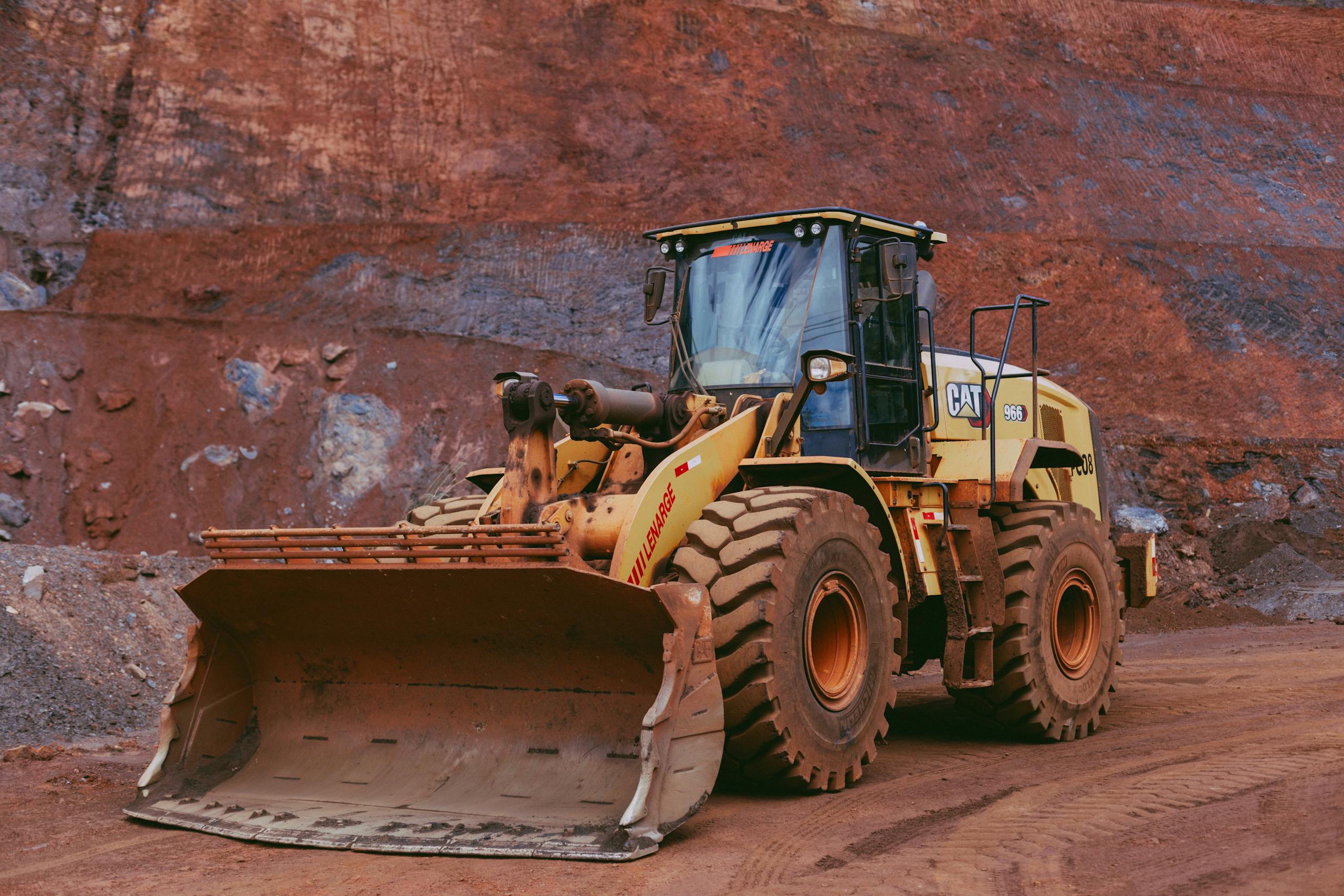 large yellow bulldozer operating in a mining quarry with rugged terrain. 31543919 scaled