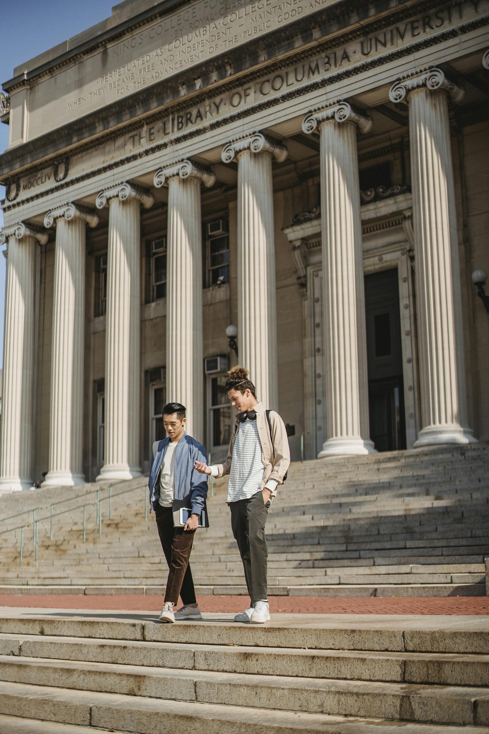 two young men descend steps at columbia university showcasing campus life and education themes. 5554240 scaled