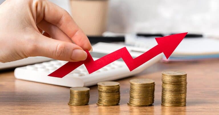 Hand holding growth arrow with coins